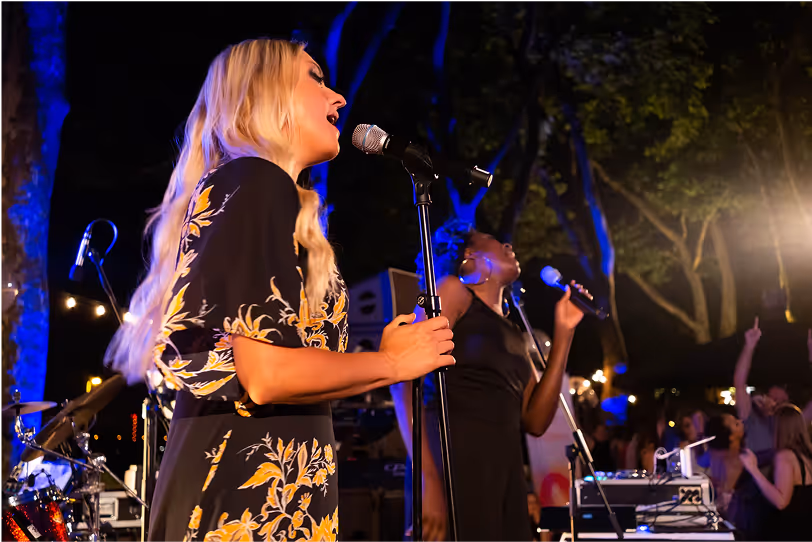 Zwei Sängerinnen bei Open-Air-Live-Show unter Lichterbäumen – musikalische Abendinszenierung von Marcel Mäder – Gravity