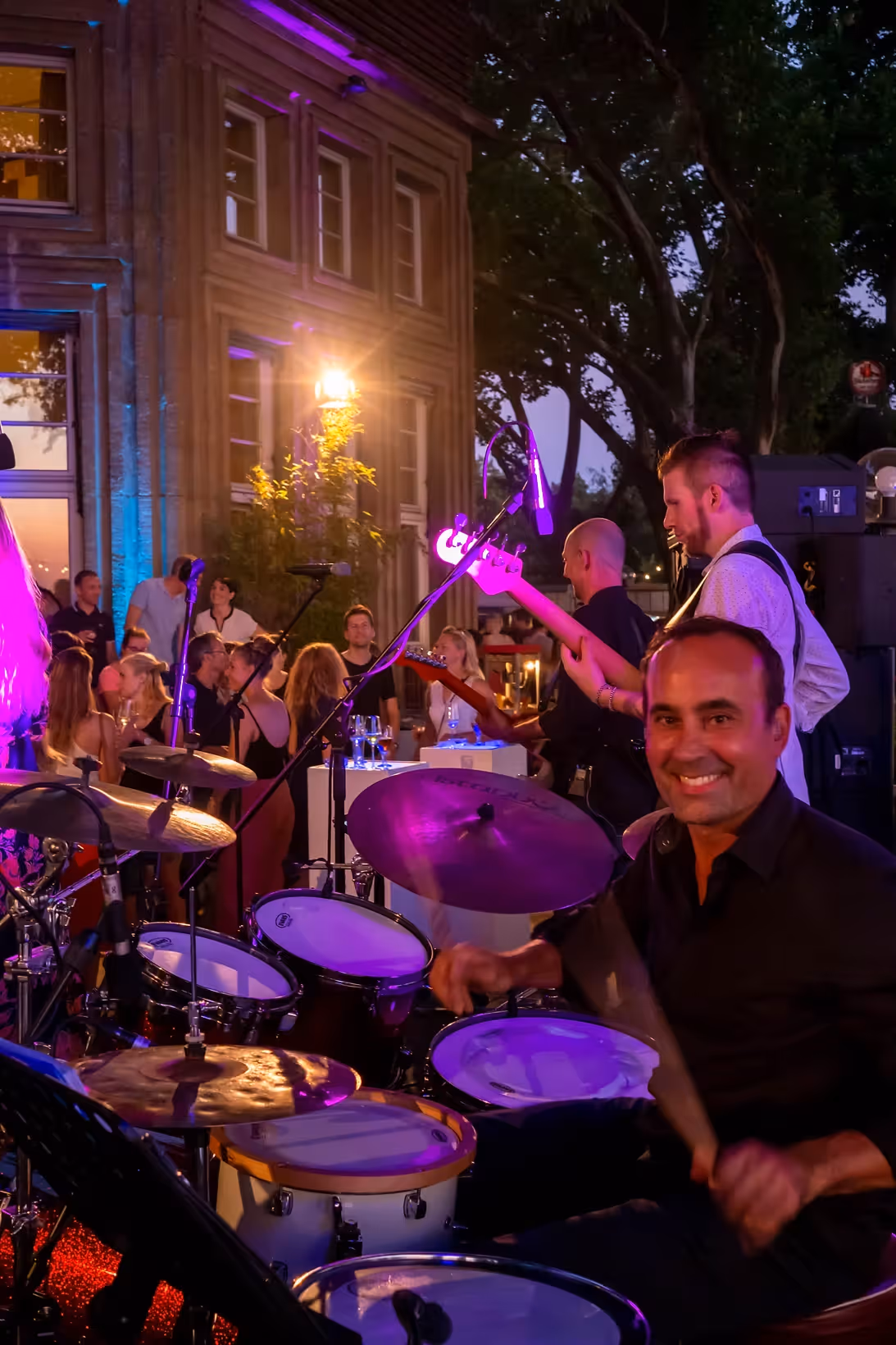 Lächelnder Drummer bei einem exklusiven Open-Air-Konzert – eingefangen von Marcel Mader für energiegeladene Musik- und Bühnenvideos.