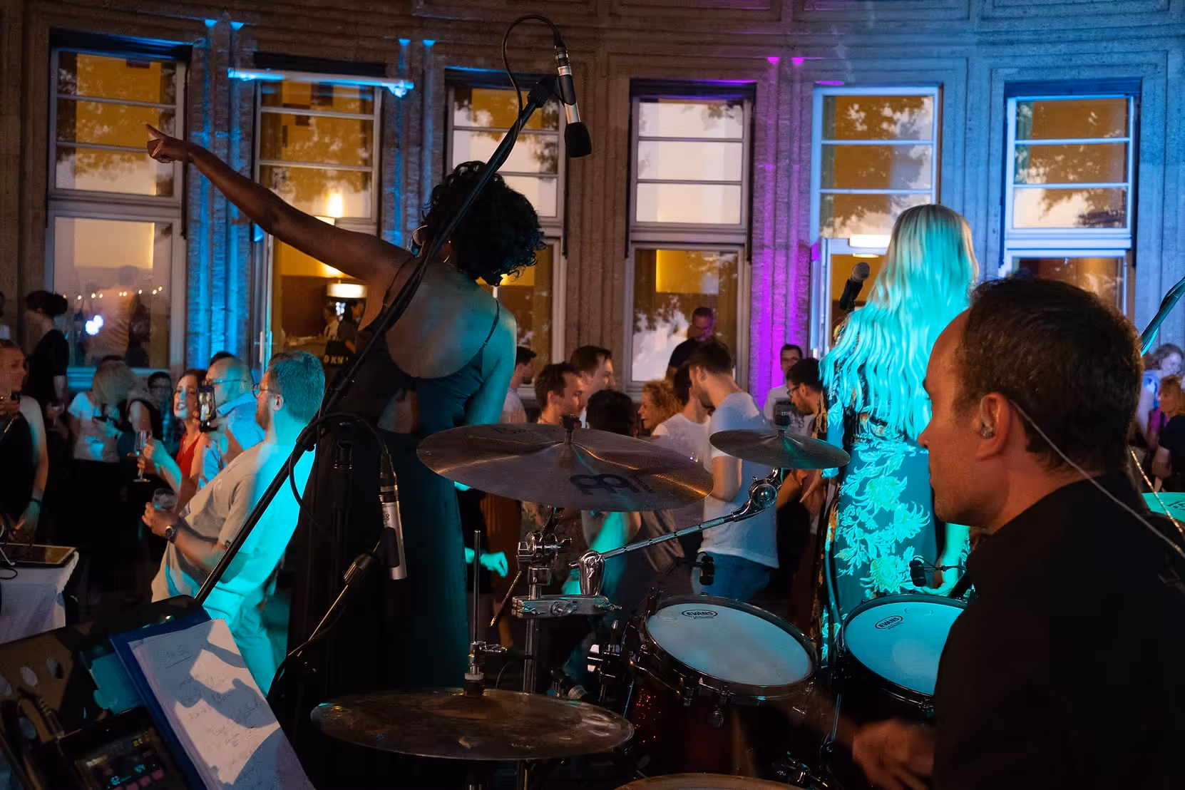 Immersive view from behind the drums during a vibrant live concert, filmed by Marcel Mader to highlight energy, performers, and event atmosphere.